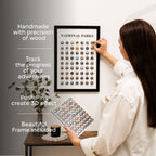 Woman hanging a framed National Parks travel map with push pins on a wall.