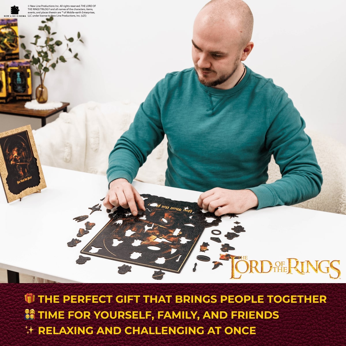 Man assembling a 'The Lord of the Rings' themed puzzle on a table.