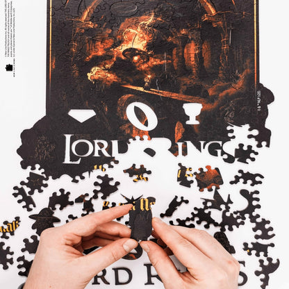 Jigsaw puzzle with 'The Lord of the Rings' branding, partially completed with hands holding a piece.