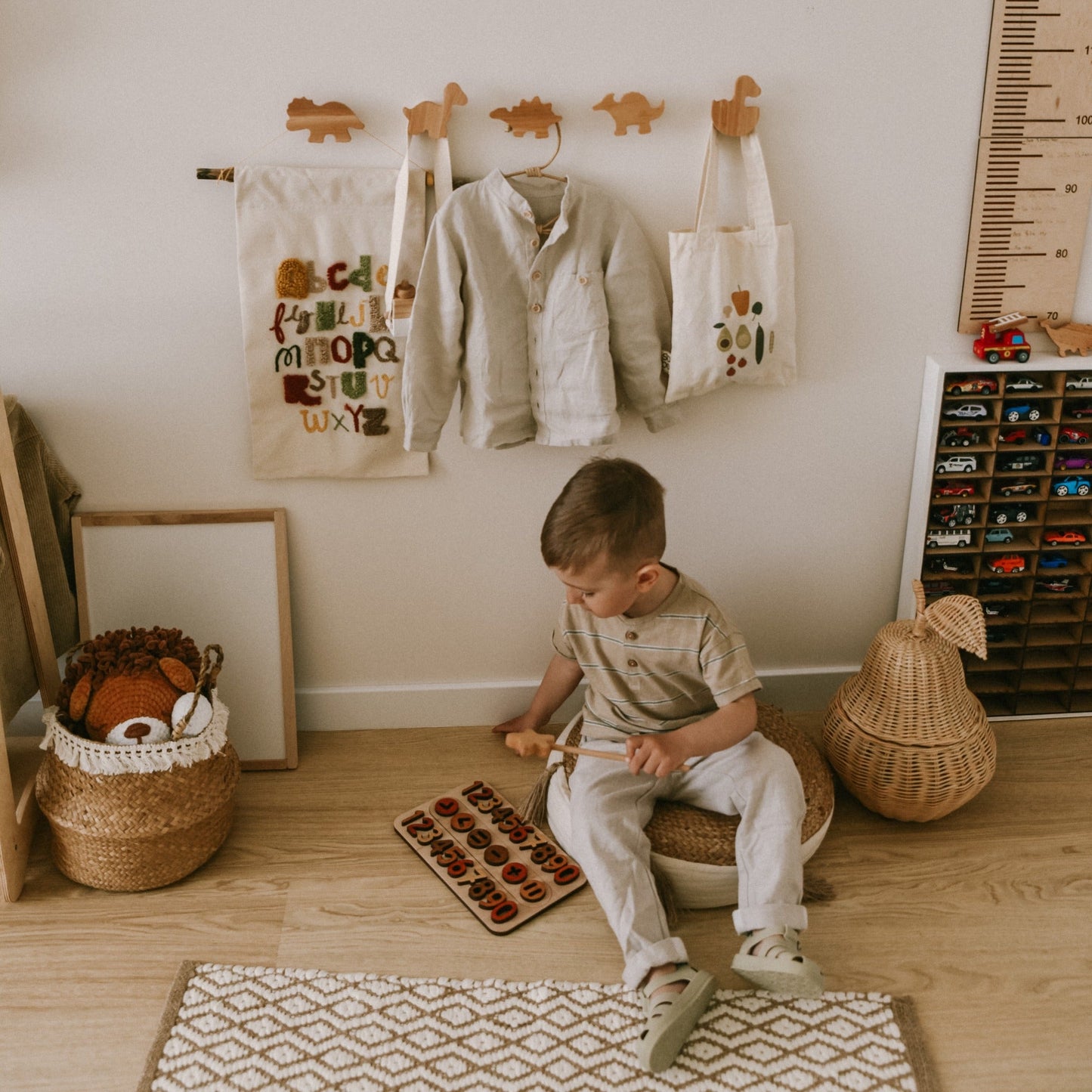 Child playing with a wooden puzzle on the floor in a child-friendly room.