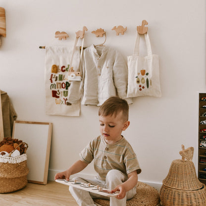 Child playing with toys in a room with white walls, wooden furniture, and decorative items.