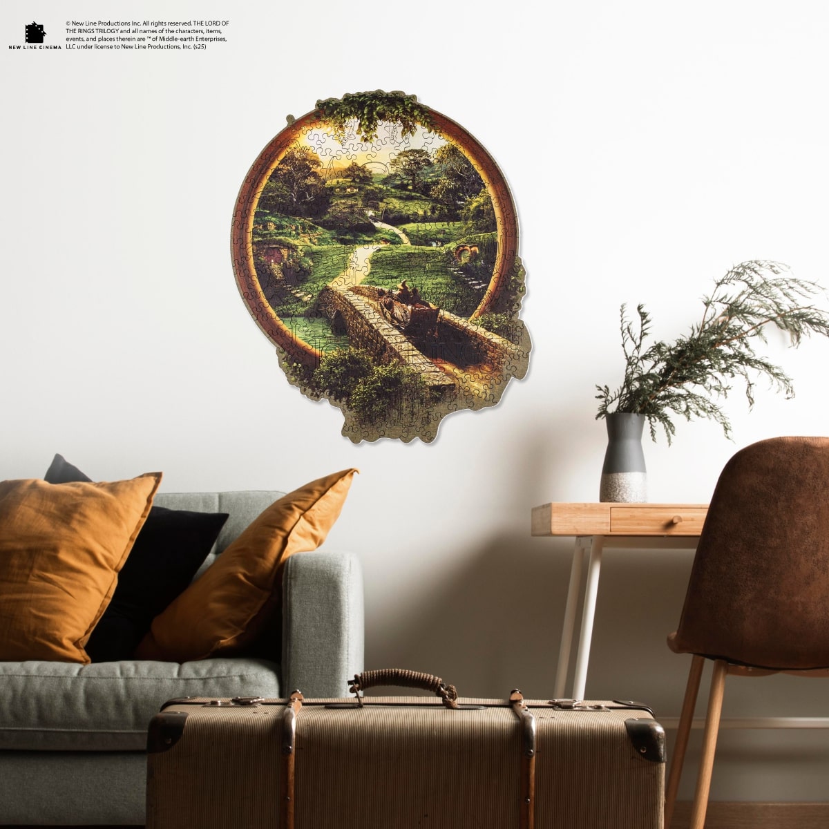 Decorative wall piece in a living room setting with a couch, suitcase, and plant.
