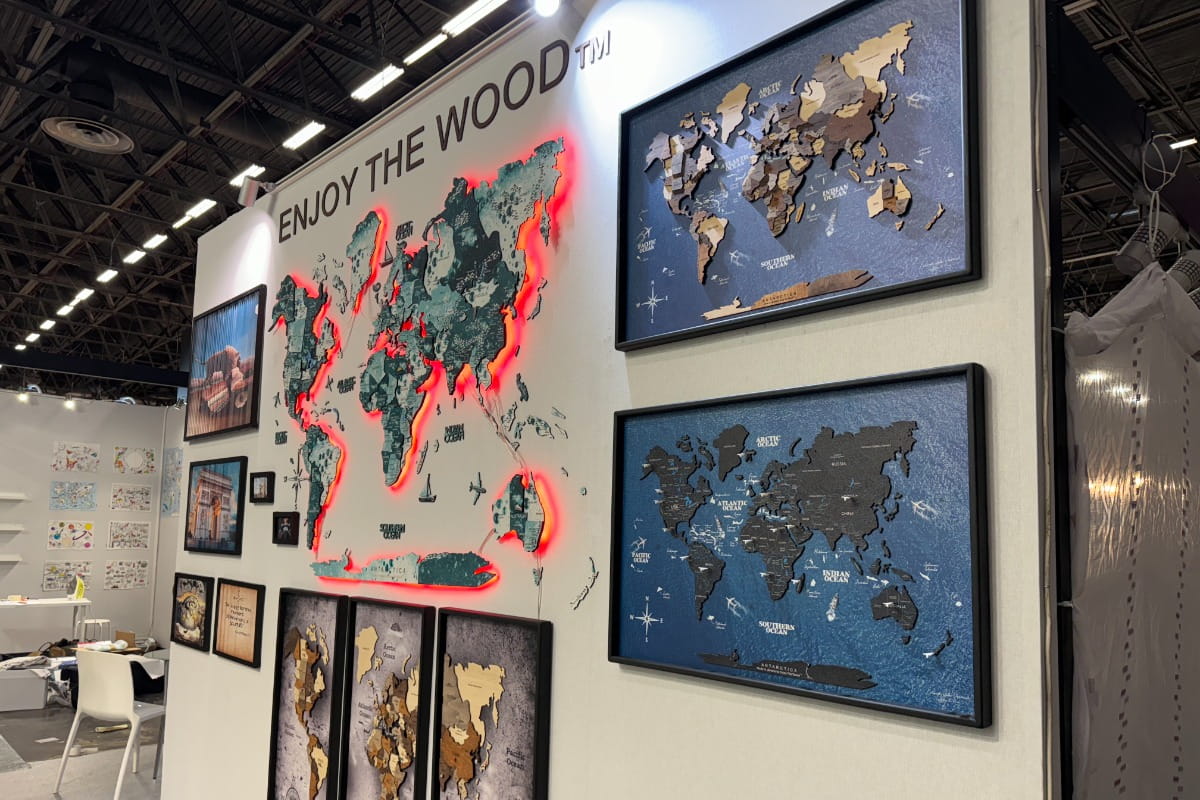 World map display with various artistic representations on a wall, featuring the brand 'Enjoy The Wood'.