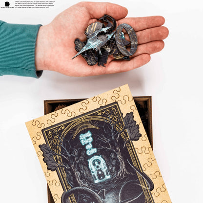 Hand holding puzzle pieces above a partially completed puzzle with a decorative cover.