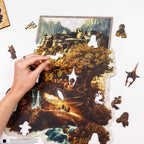 Living room with a gray sofa, brown chair, and a wall art piece depicting a scenic landscape.