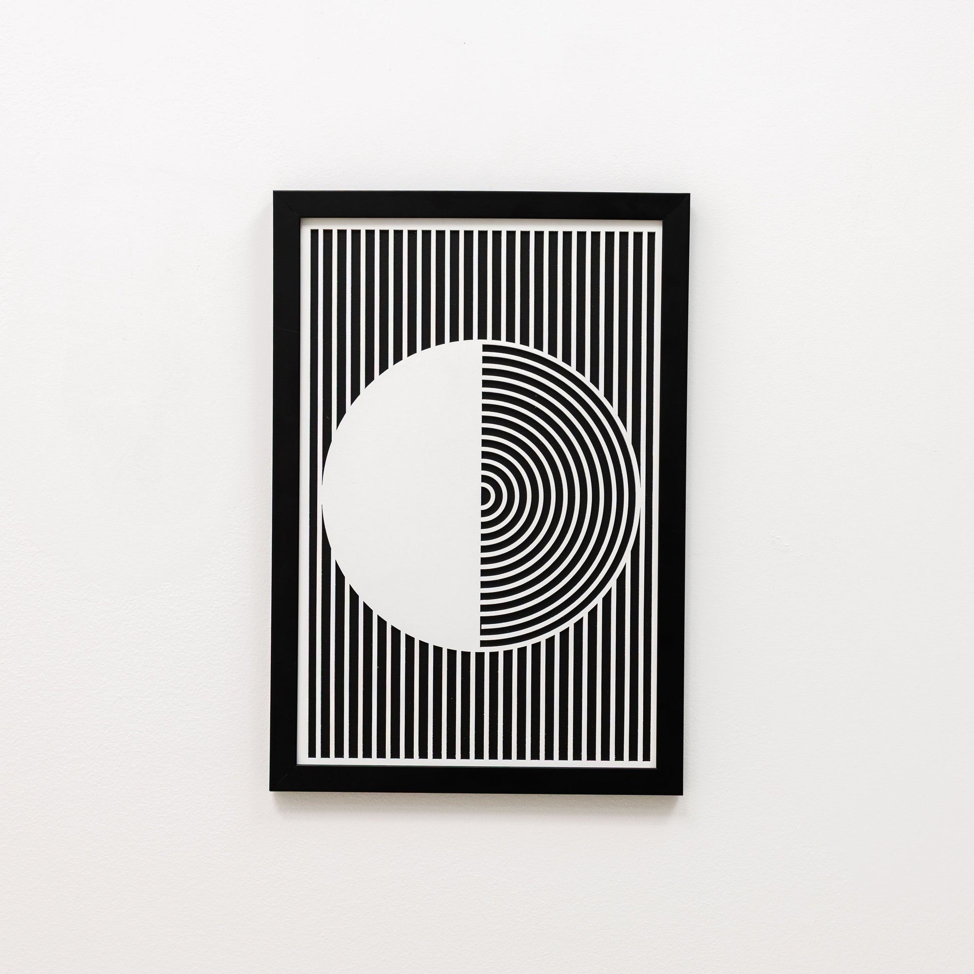 Framed black and white geometric art print on a white wall