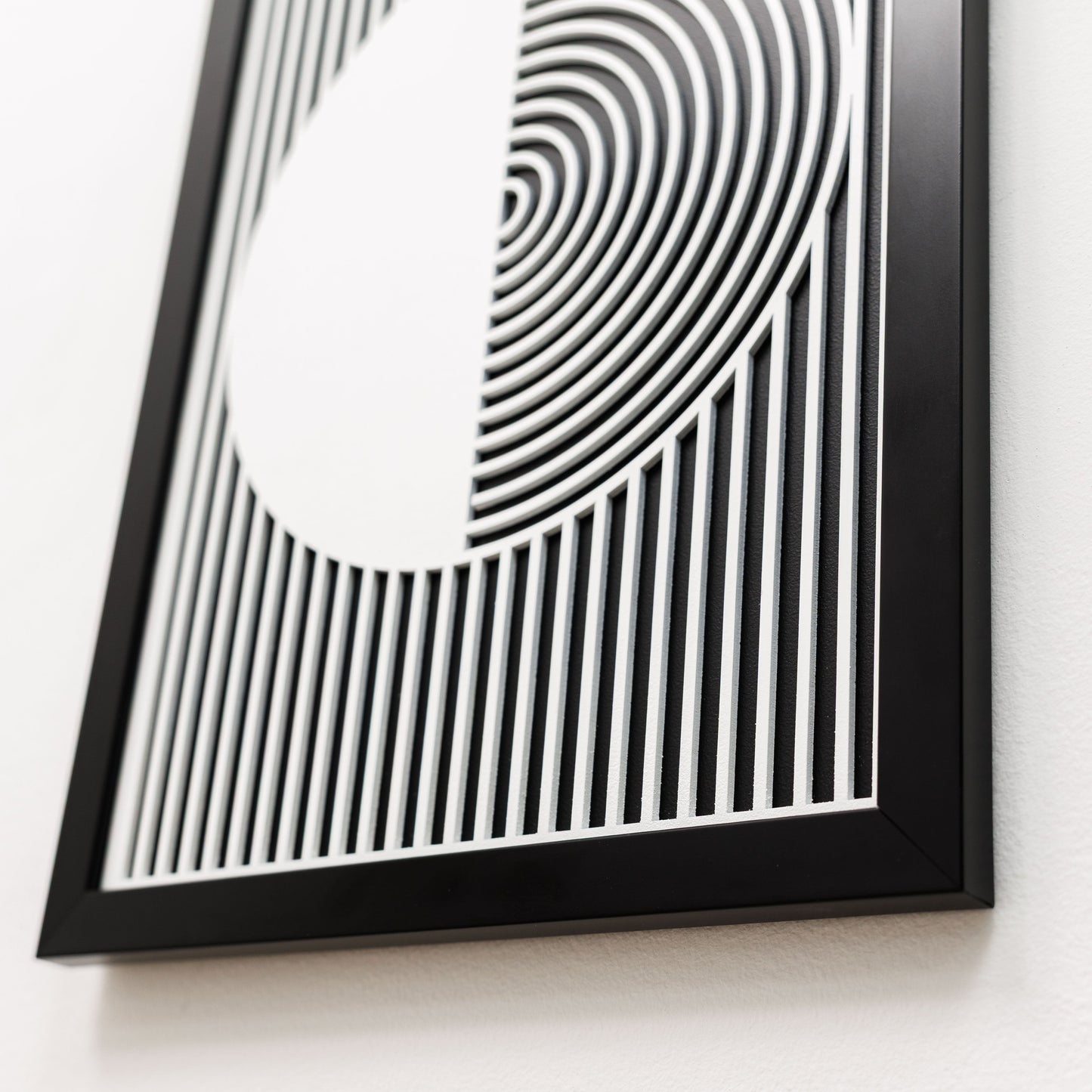 Framed black and white abstract art piece on a white background
