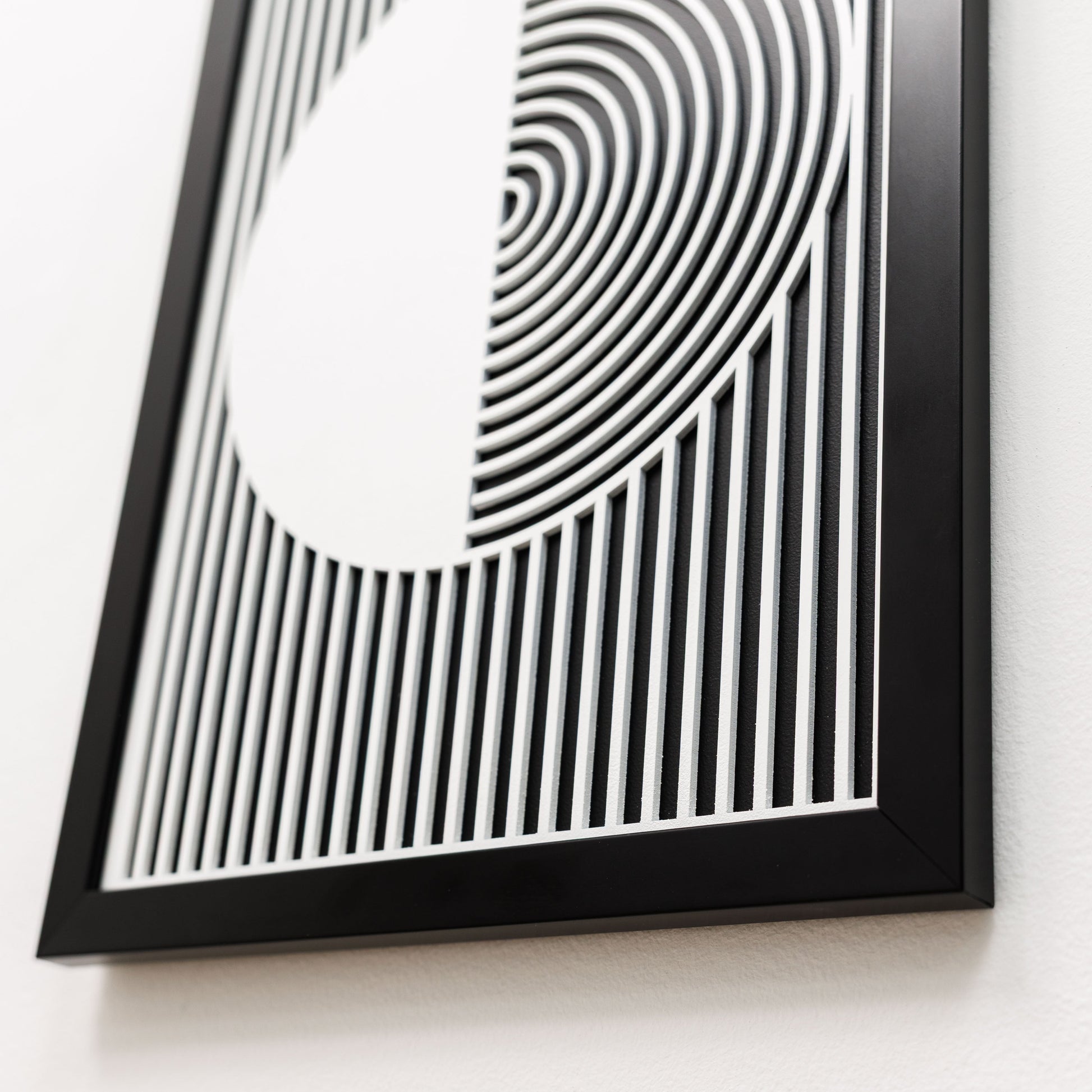 Framed black and white abstract art piece on a white background