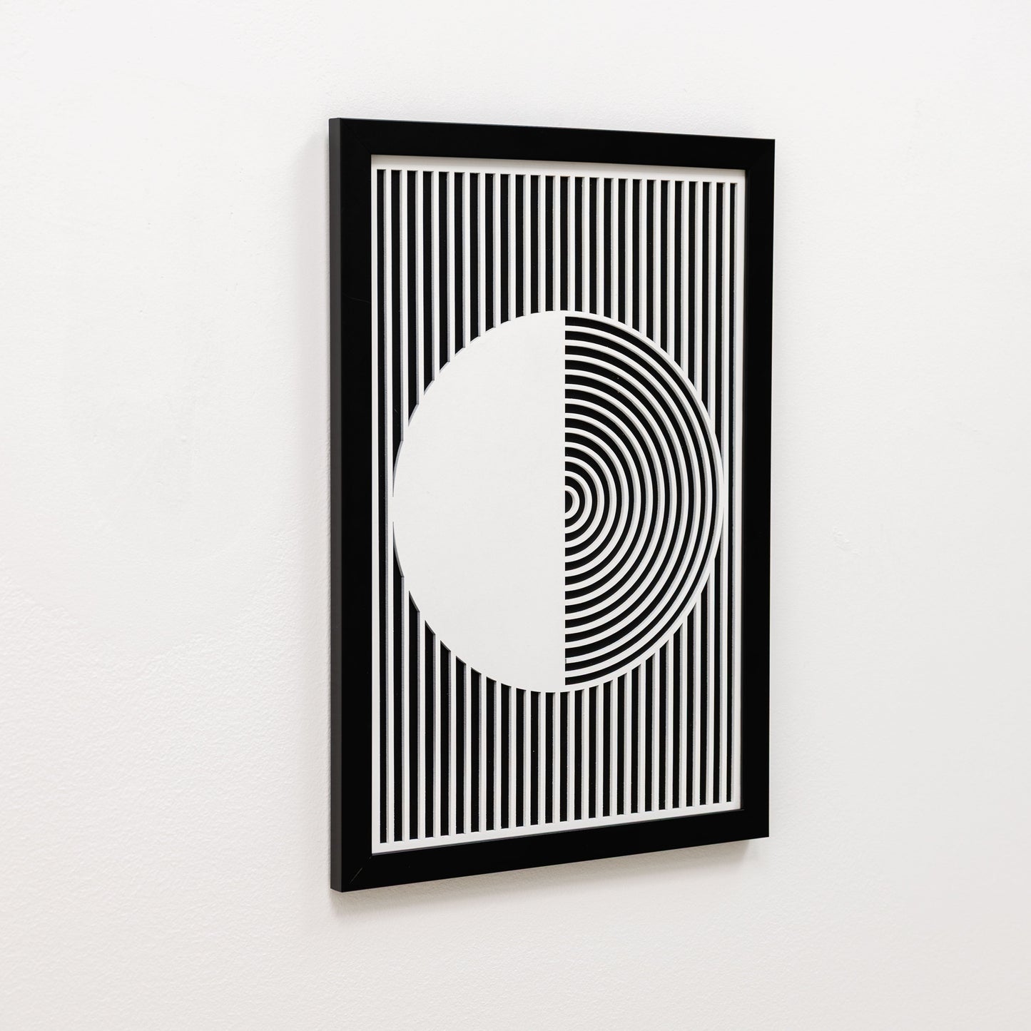 Framed black and white geometric art print on a white wall