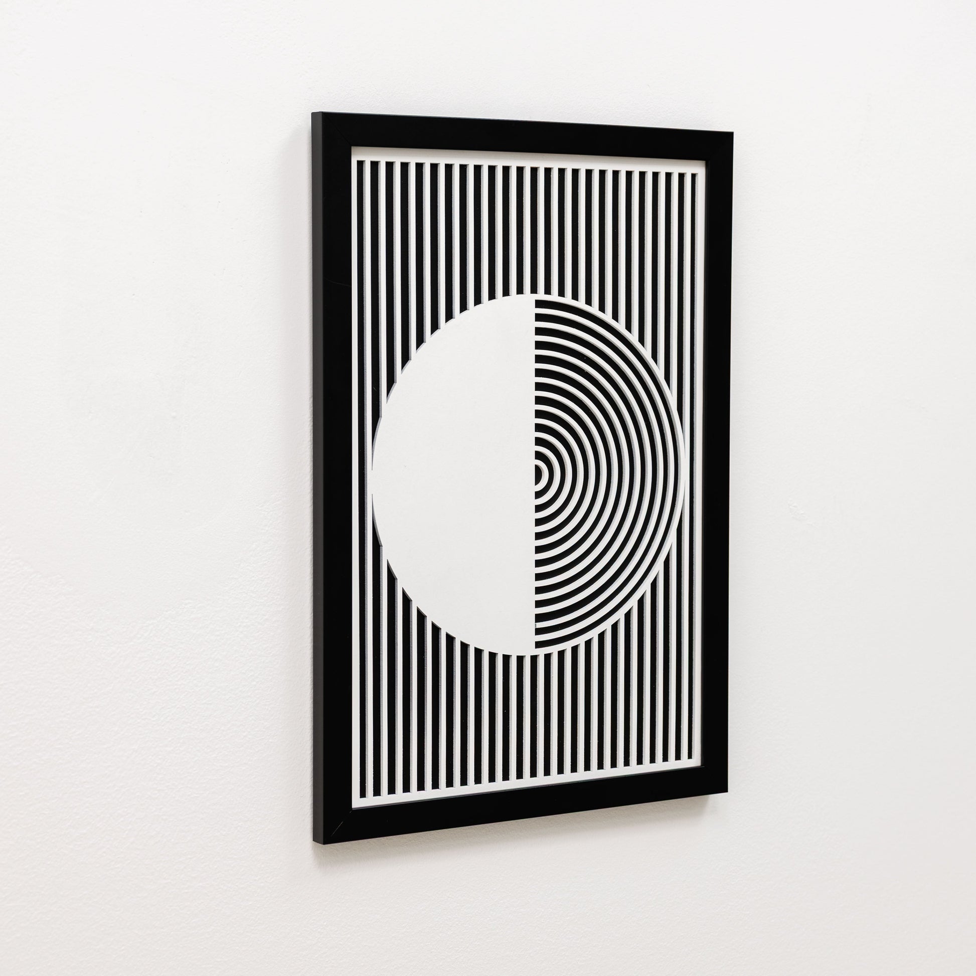 Framed black and white geometric art print on a white wall