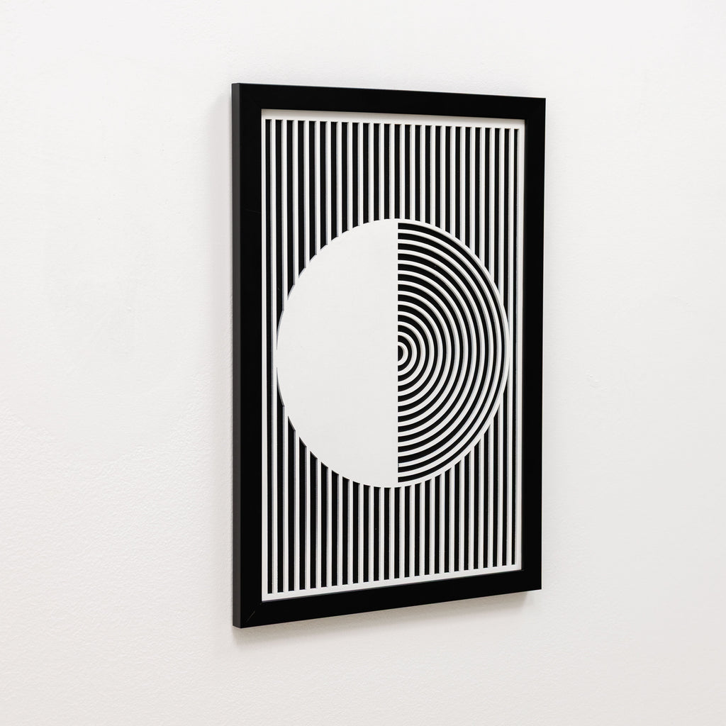 Framed black and white geometric art print on a white wall
