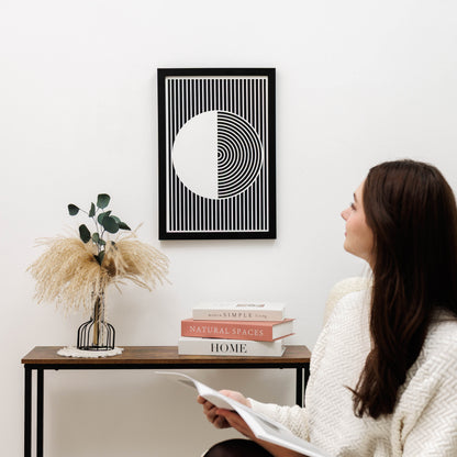 Woman sitting in a room with a modern abstract art piece on the wall.