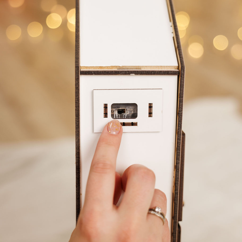 Hand pressing a light switch with blurred lights in the background