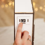 Hand pressing a light switch with blurred lights in the background