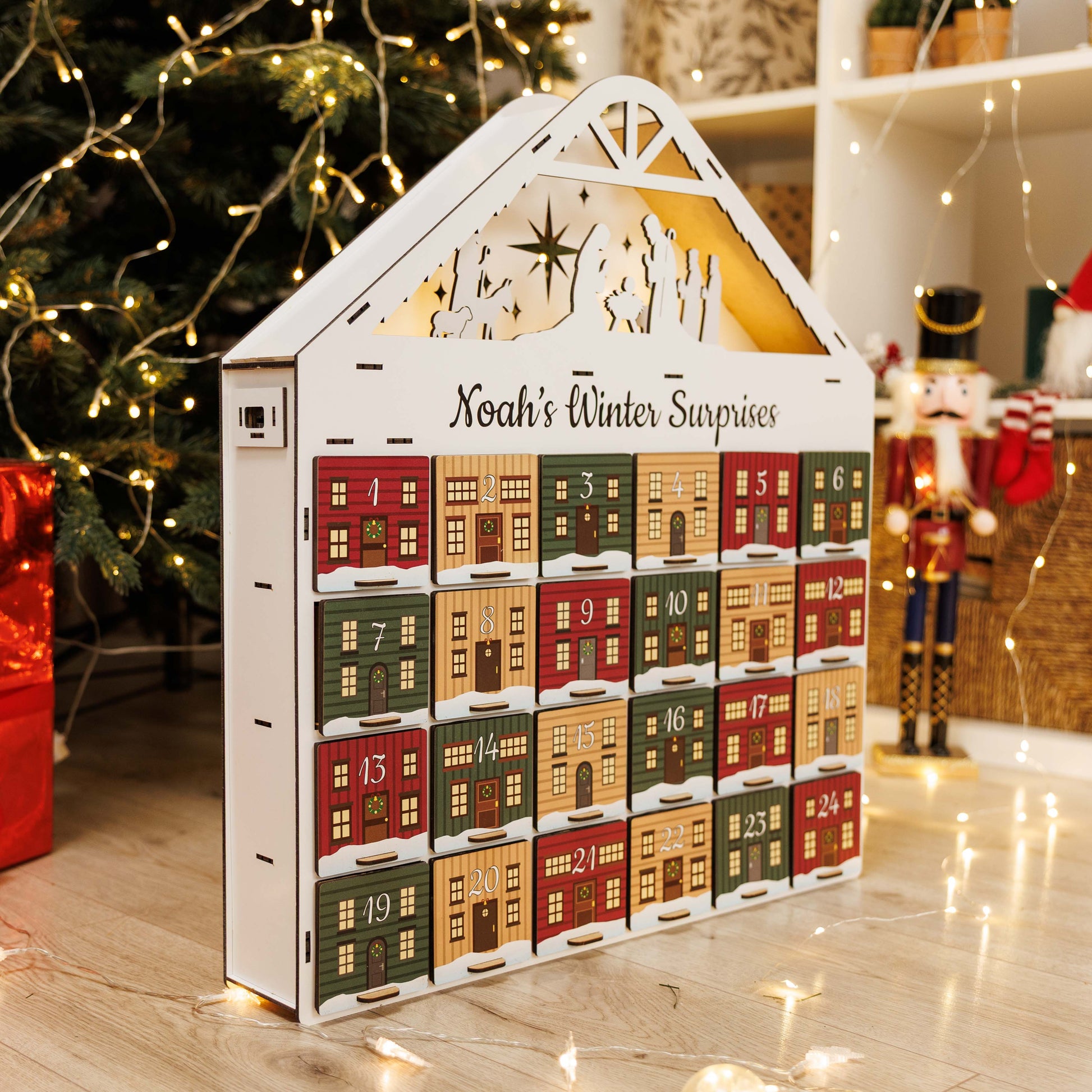 Advent calendar shaped like a house with Christmas decorations in the background