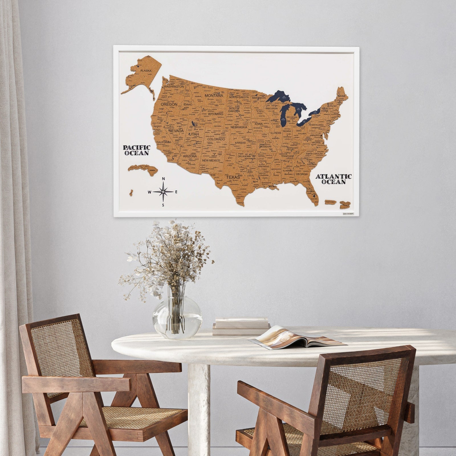 Dining room with a framed map of the United States on the wall above a table.