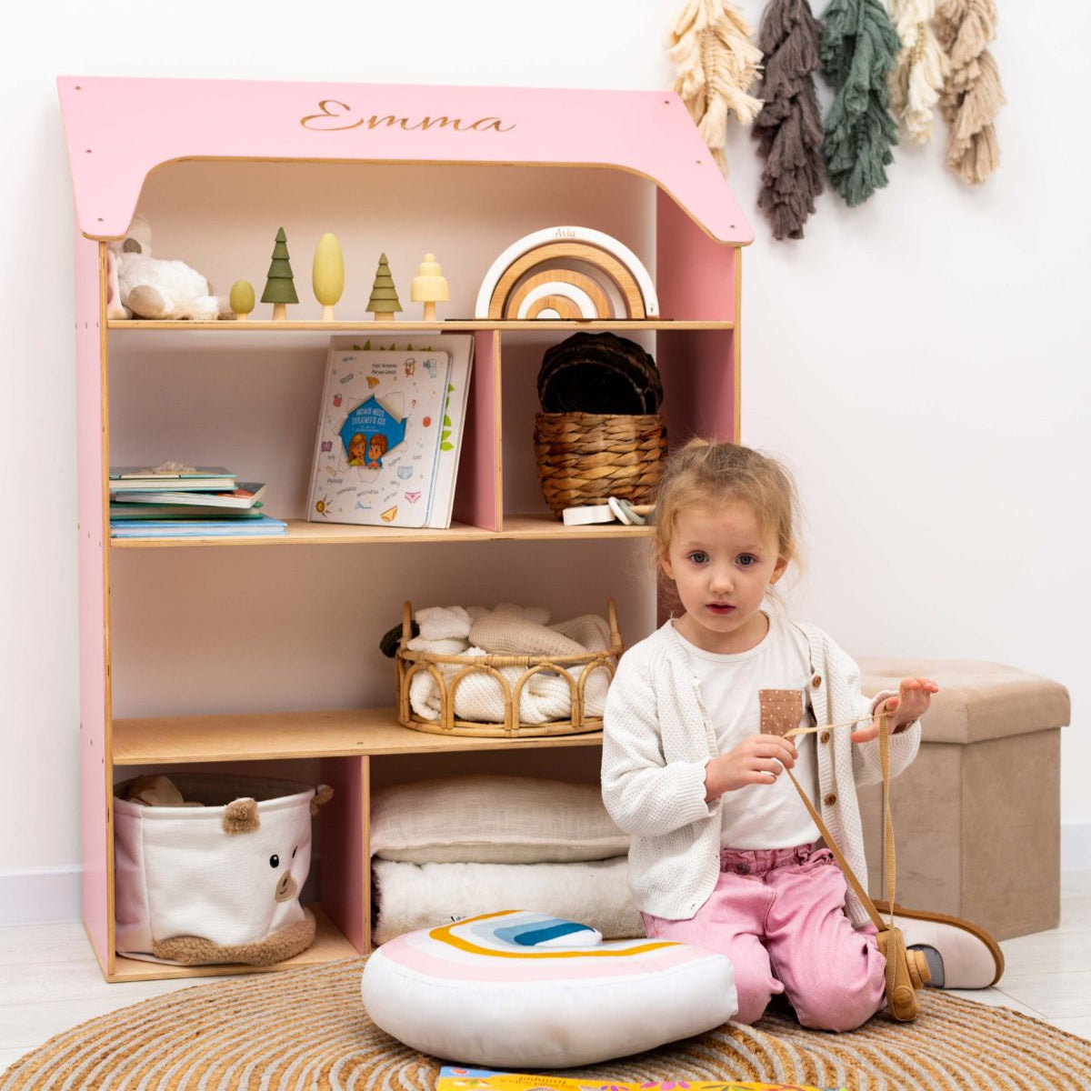 pink child-sized wooden doll house bookcase for nursery