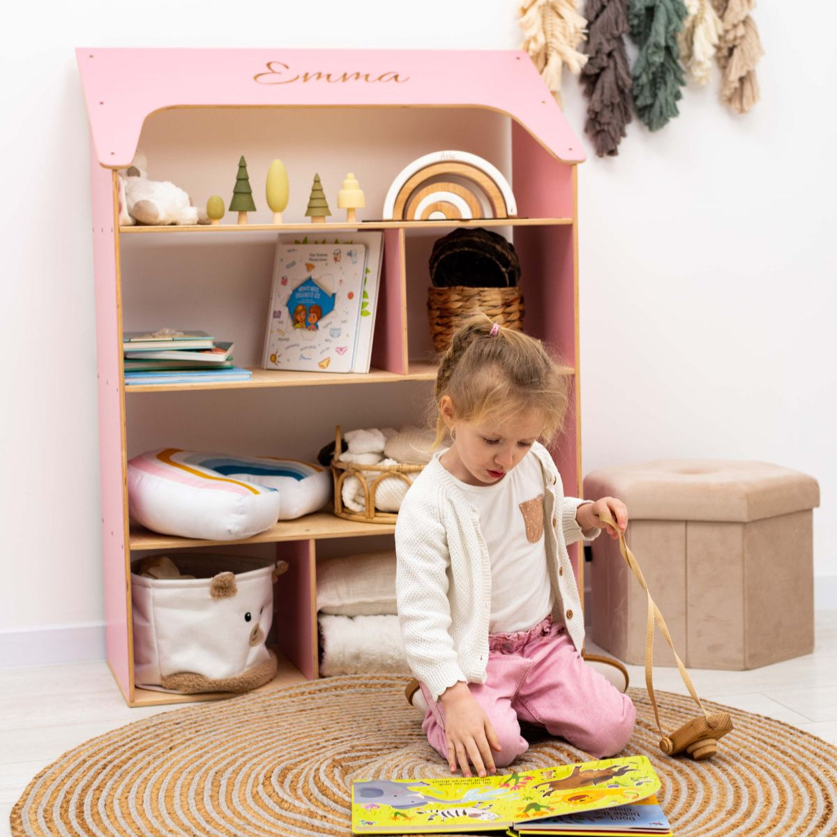 pink child-sized dolls house shaped bookcase
