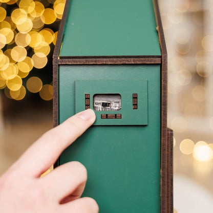 Hand pressing a button on a green door with blurred lights in the background