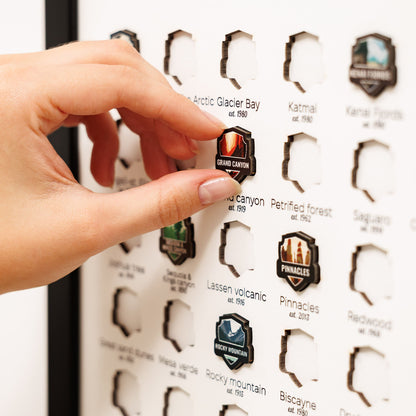 Hand interacting with a display of National Park pins