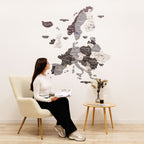 Woman sitting in a chair in front of a large wall map of Europe.