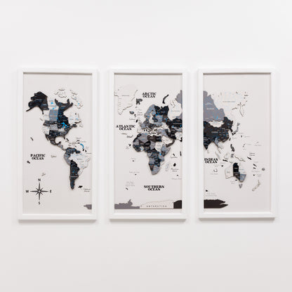Three framed world maps on a white wall