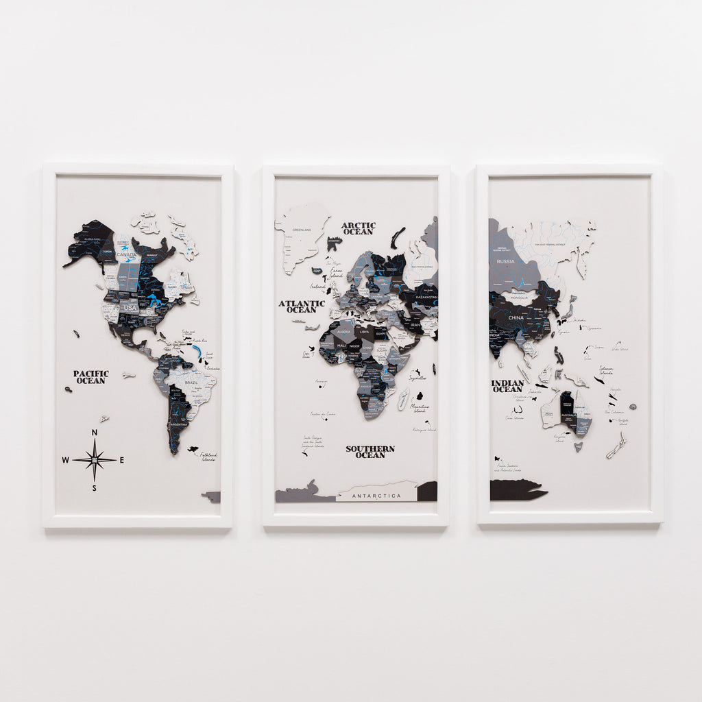 Three framed world maps on a white wall