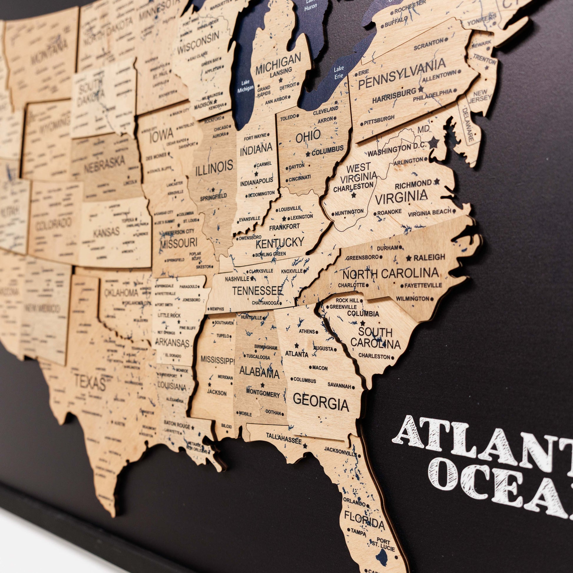 Wooden map of the United States with state names on a black background