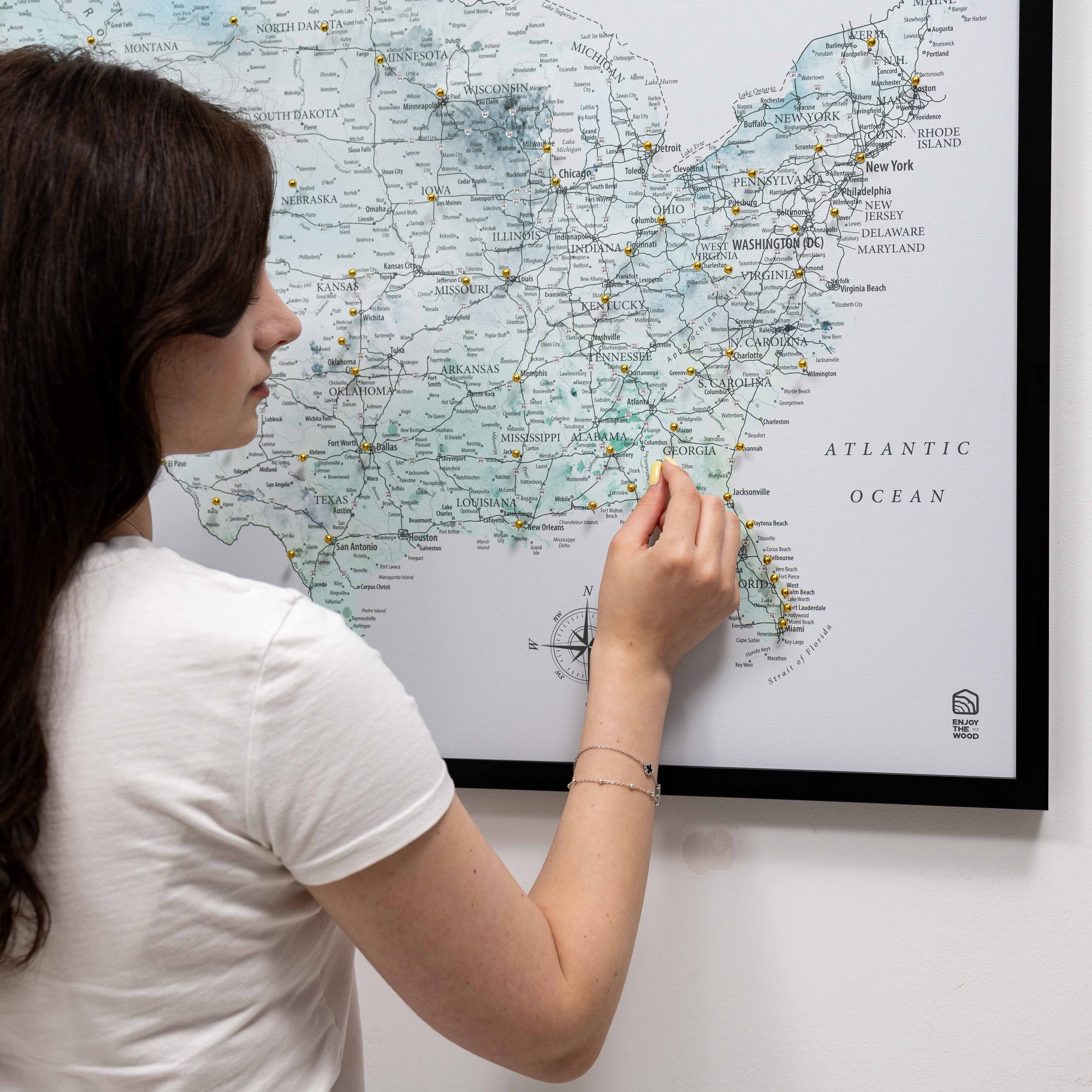 Woman marking a location on a map of the United States.