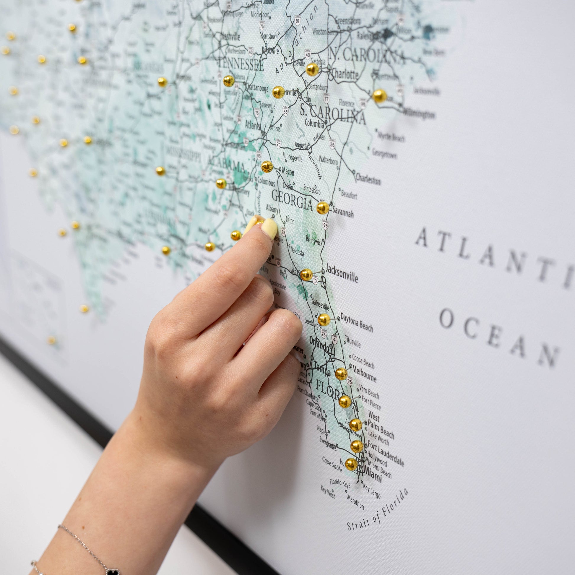 Map of Georgia with pins and a hand pointing to a location