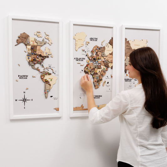 Woman interacting with a wooden world map on a wall