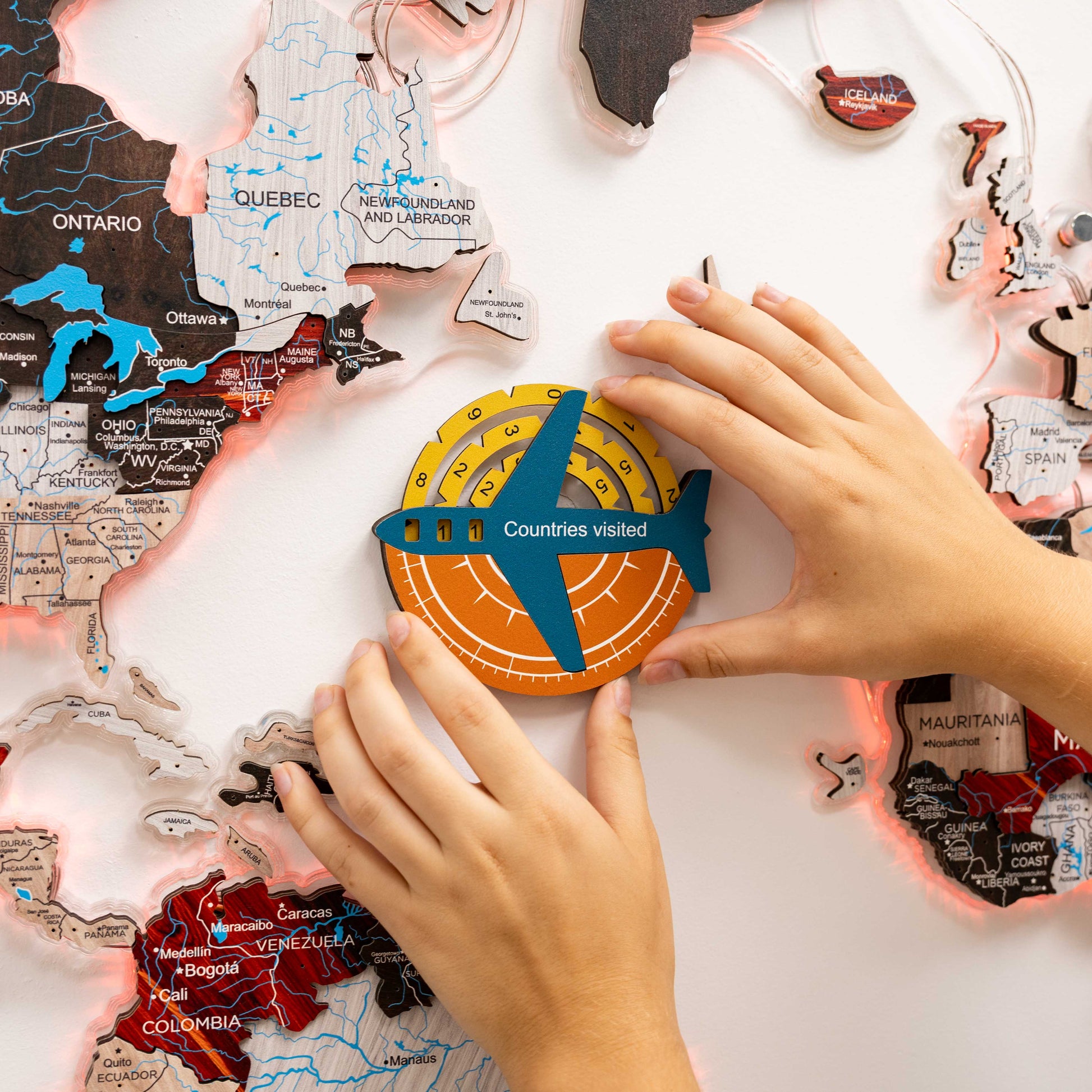 Map of Canada with a 'Countries visited' round sticker being placed by hands