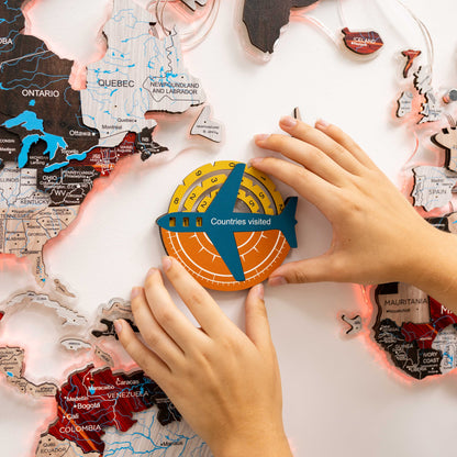 Map of Canada with a 'Countries visited' round sticker being placed by hands