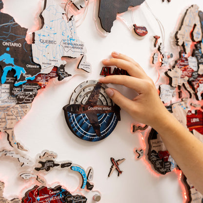 Map with travel stickers and a hand placing a sticker on it