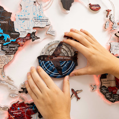 Hands arranging a world map puzzle on a white surface