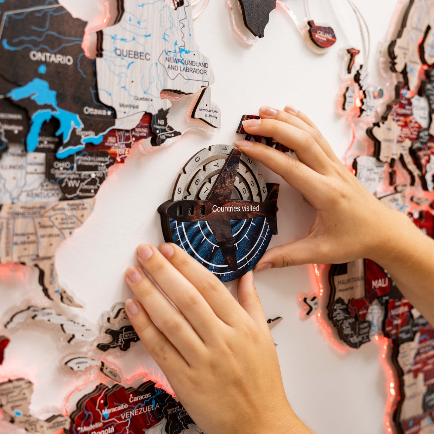 Person interacting with a map-themed puzzle, focusing on a circular component labeled 'Countries visited'.