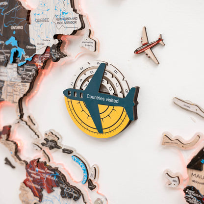 Decorative item with airplane design and 'Countries visited' text on a world map background