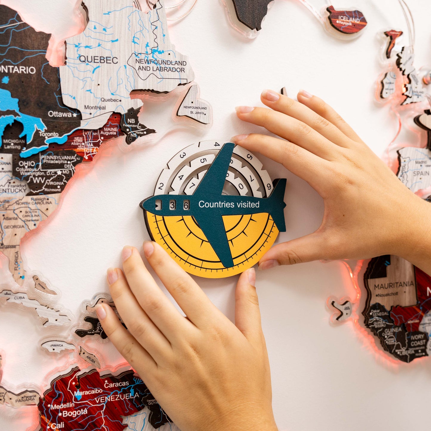 Map of Canada with a 'Countries visited' compass and hands interacting with it