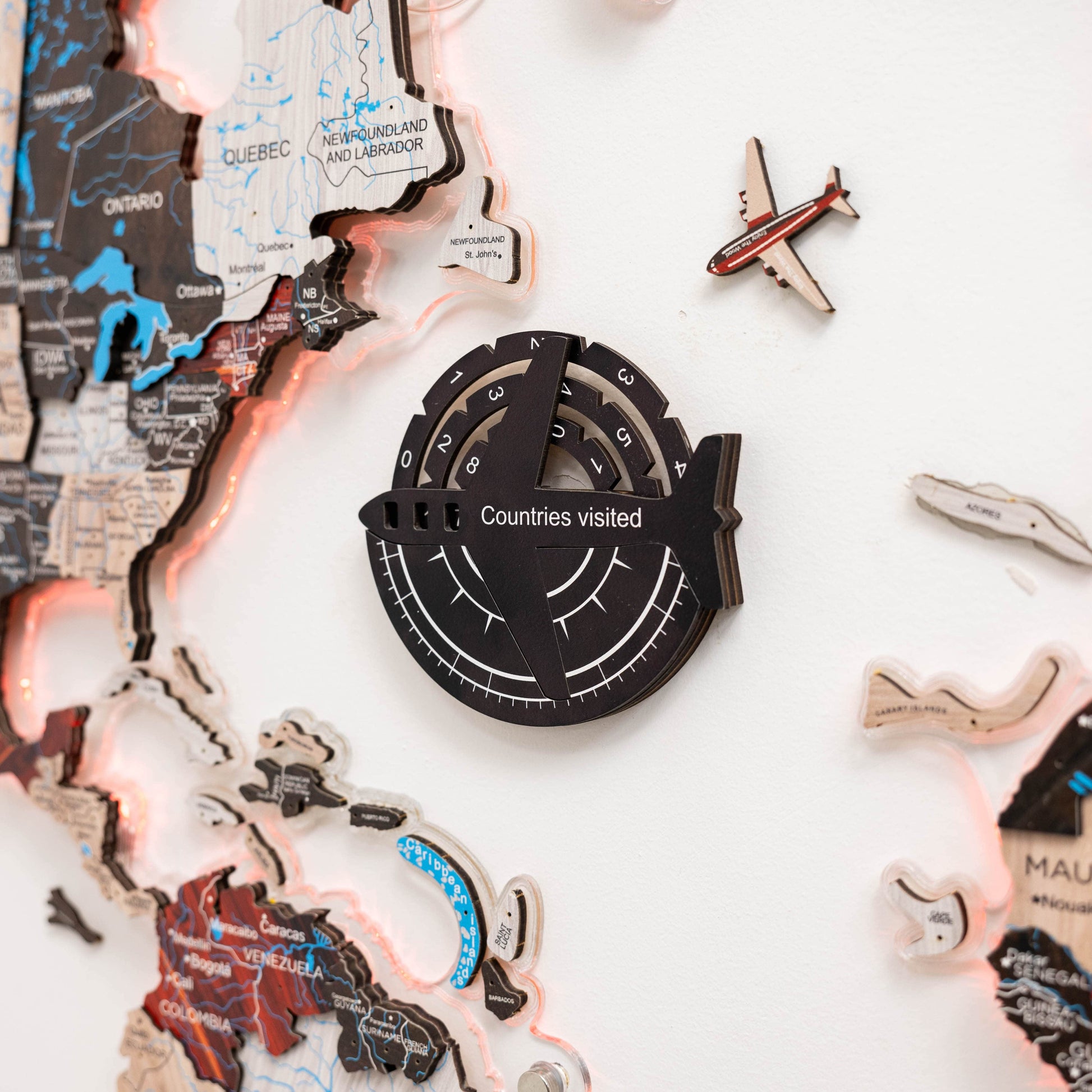 Circular travel tracker with 'Countries visited' text, surrounded by world map cutouts and airplane figurines on a white background.