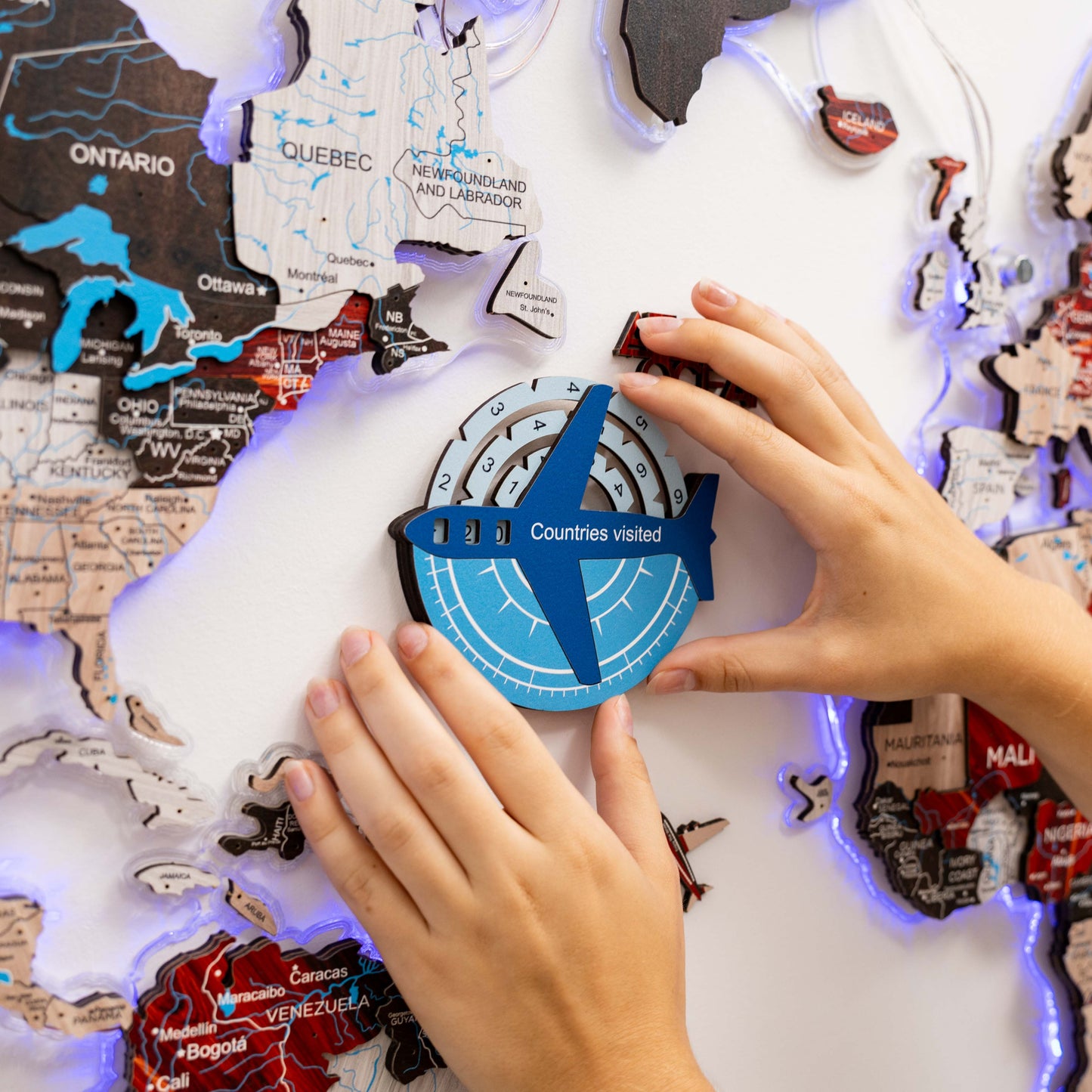 Person interacting with a map-themed product featuring a compass and 'Countries visited' counter.