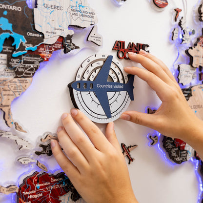 Person interacting with a travel-themed board game or poster, featuring a compass and airplane icon.
