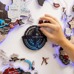 Hand interacting with a travel-themed decorative item featuring world map and travel stickers.