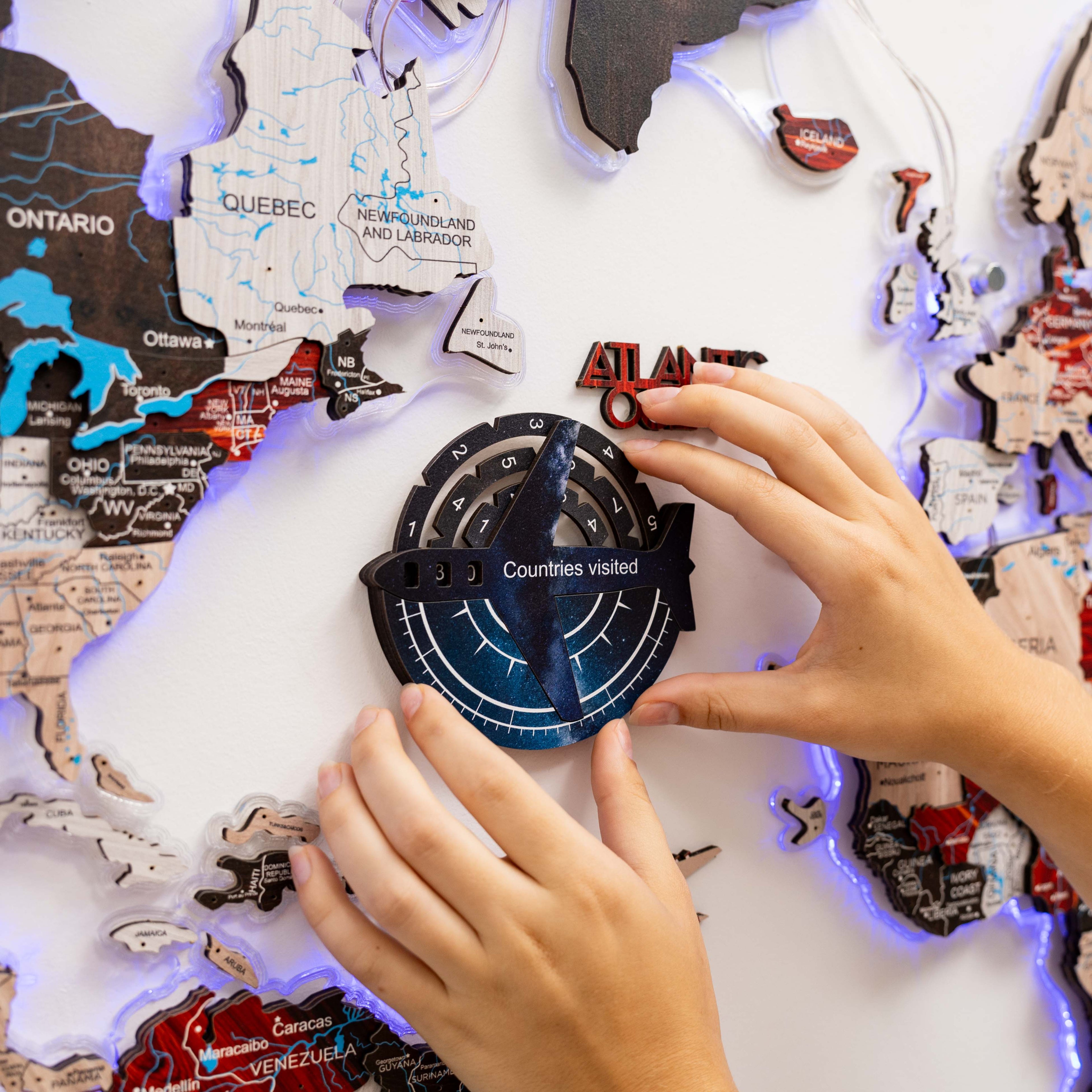 Person interacting with a world map puzzle featuring a compass component.