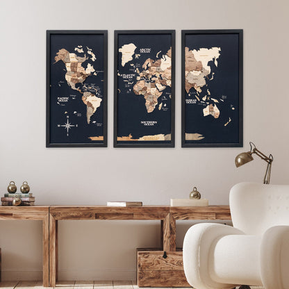 Three framed world maps on a wall above a wooden desk with decorative items.
