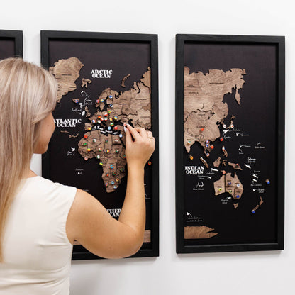 Woman interacting with a world map on a wall, with two framed world maps displayed.