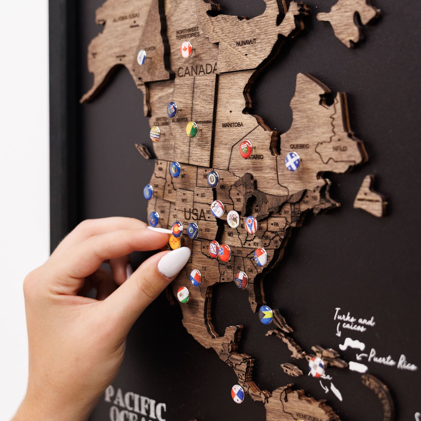 Wooden map of the United States with pins on a dark background