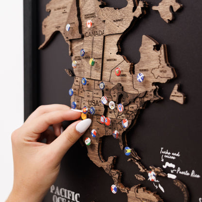 Wooden map of the United States with pins on a dark background
