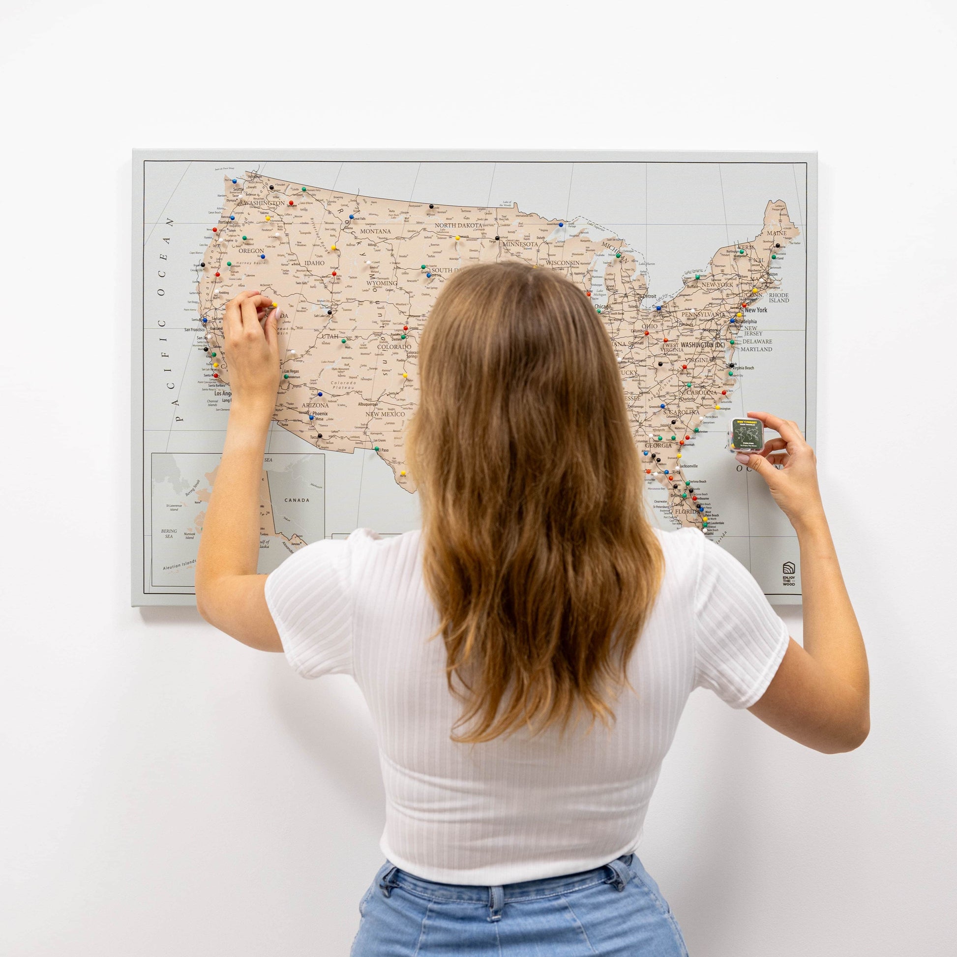 Woman looking at a map of the United States on a wall