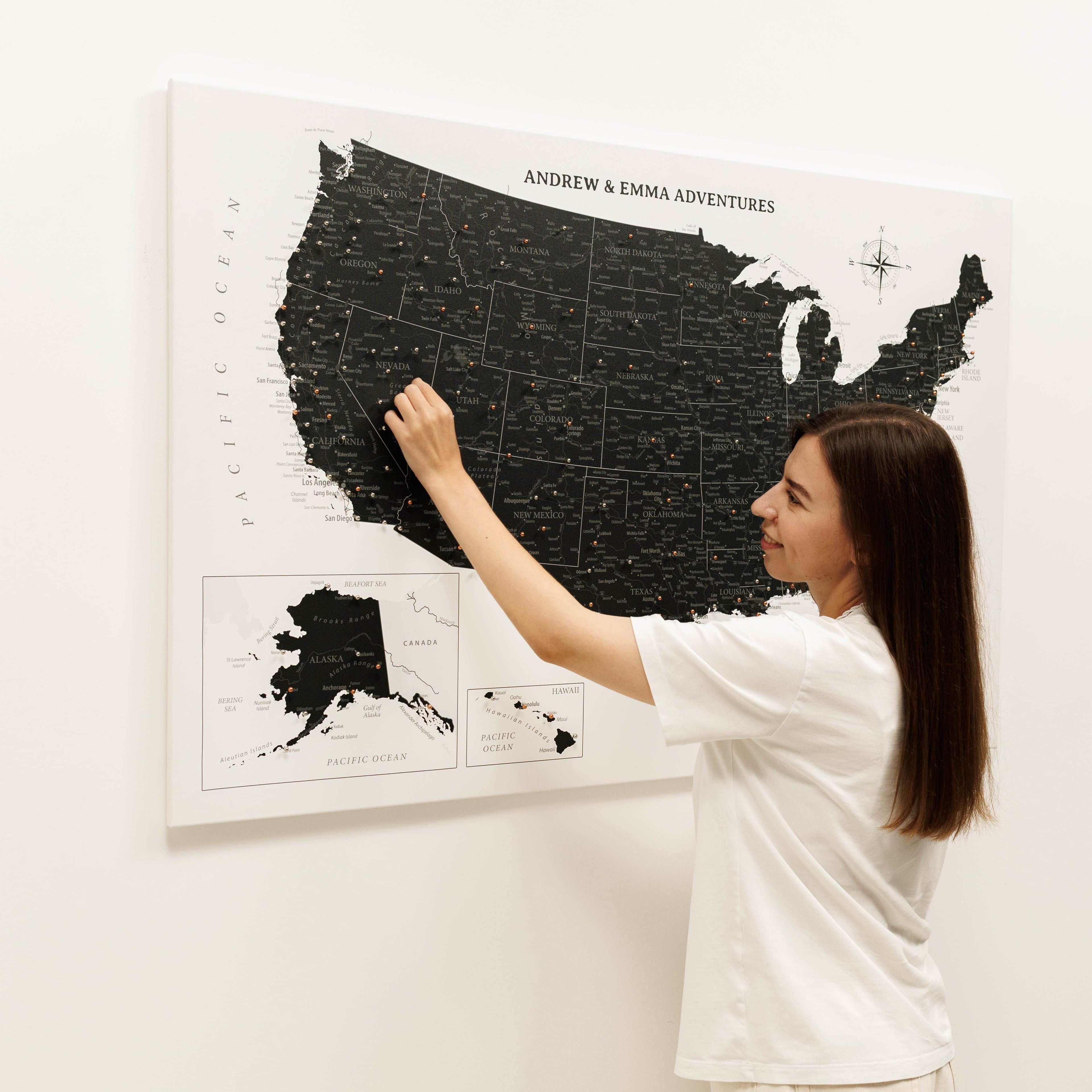 Woman interacting with a large map of the United States on a wall.