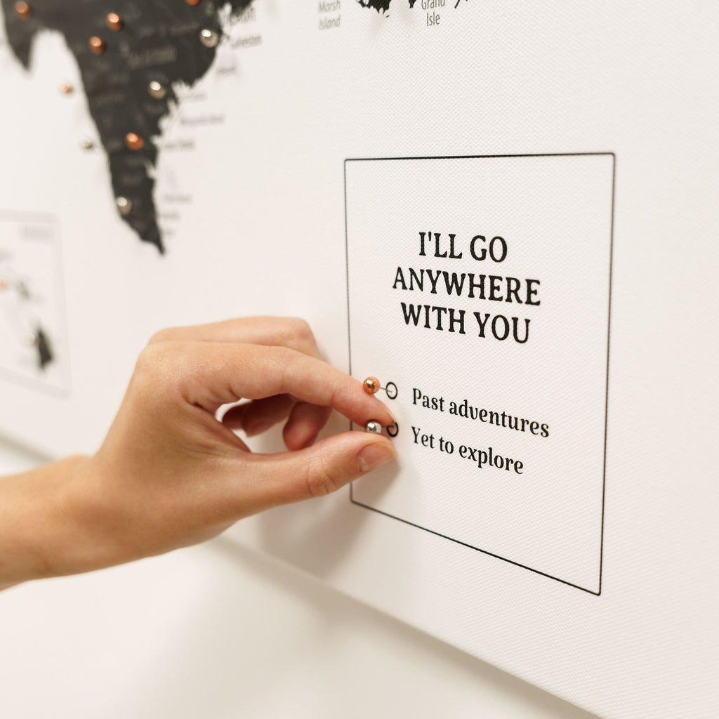 Hand placing a card with 'I'll go anywhere with you' text on a world map.